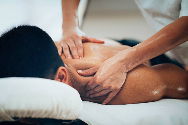 Homme couché sur le dos recevant un massage